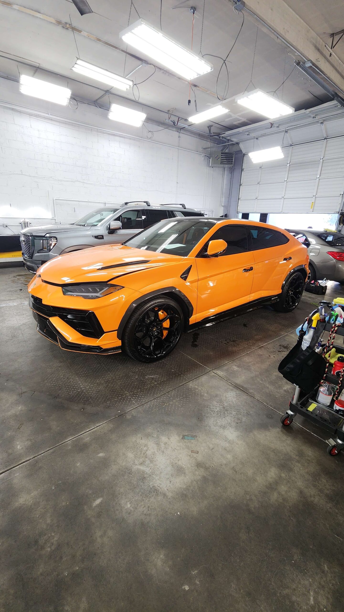 Professional window tint installer applying film with precision tools.